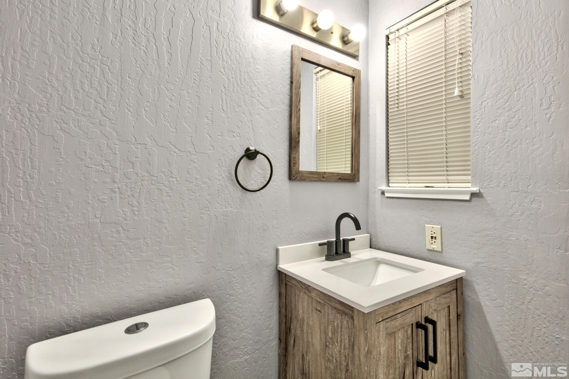 313 Tramway Drive, Unit 4 Stateline, NV 89449 - Photo 13 of 26 a bathroom with a sink a toilet and a mirror