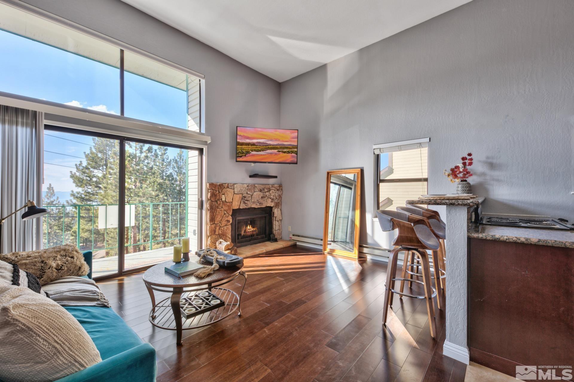 313 Tramway Drive, Unit 4 Stateline, NV 89449 - Photo 4 of 26 a living room with furniture a fireplace and a floor to ceiling window