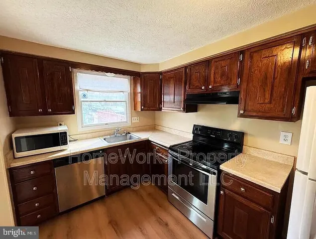 a kitchen with a stove a sink and a microwave