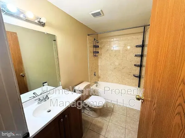 a bathroom with a sink mirror and a shower