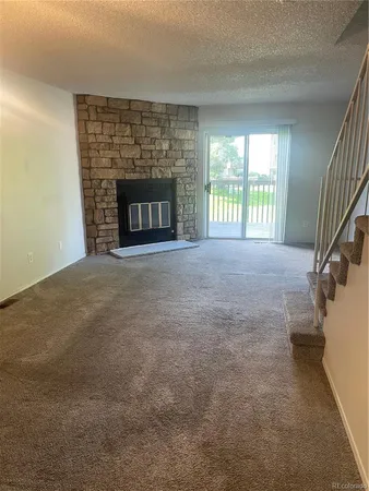 a view of an empty room with a fireplace and a window