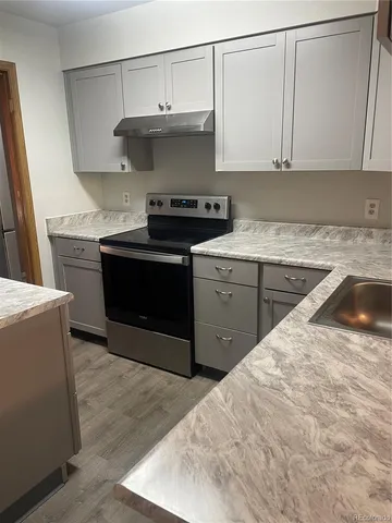 a kitchen with stainless steel appliances granite countertop a sink stove and cabinets