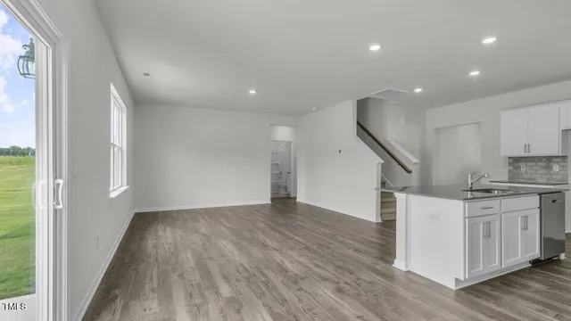 an empty room with wooden floor and electronic appliances