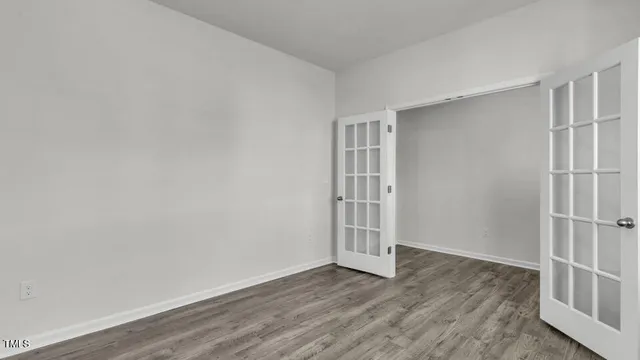an empty room with wooden floor and door