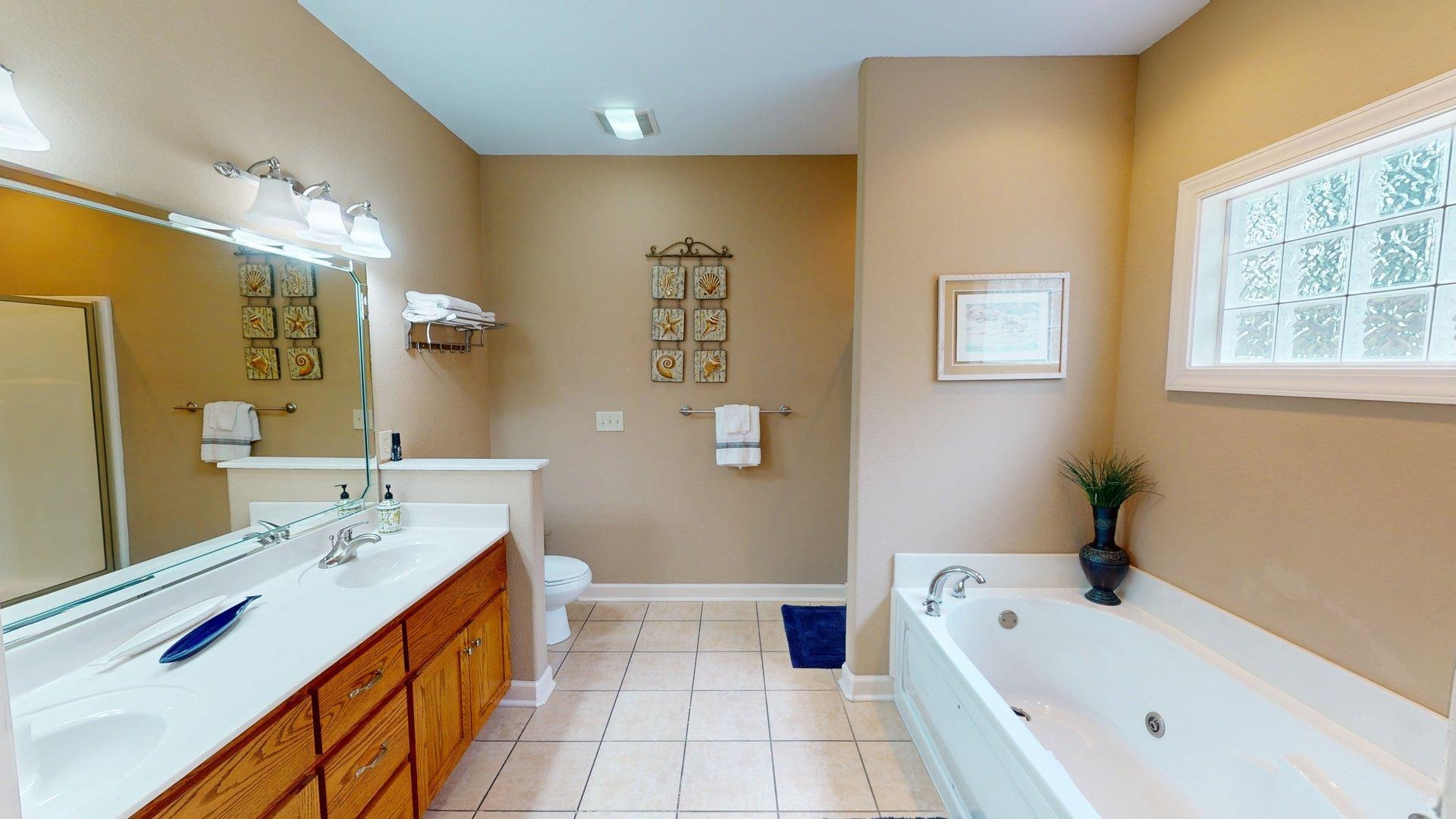 1085 Caney Hollow Road Counce, TN 38326 - Photo 13 of 39 Bathroom with double vanity, a whirlpool tub, tile patterned flooring, toilet, and baseboards