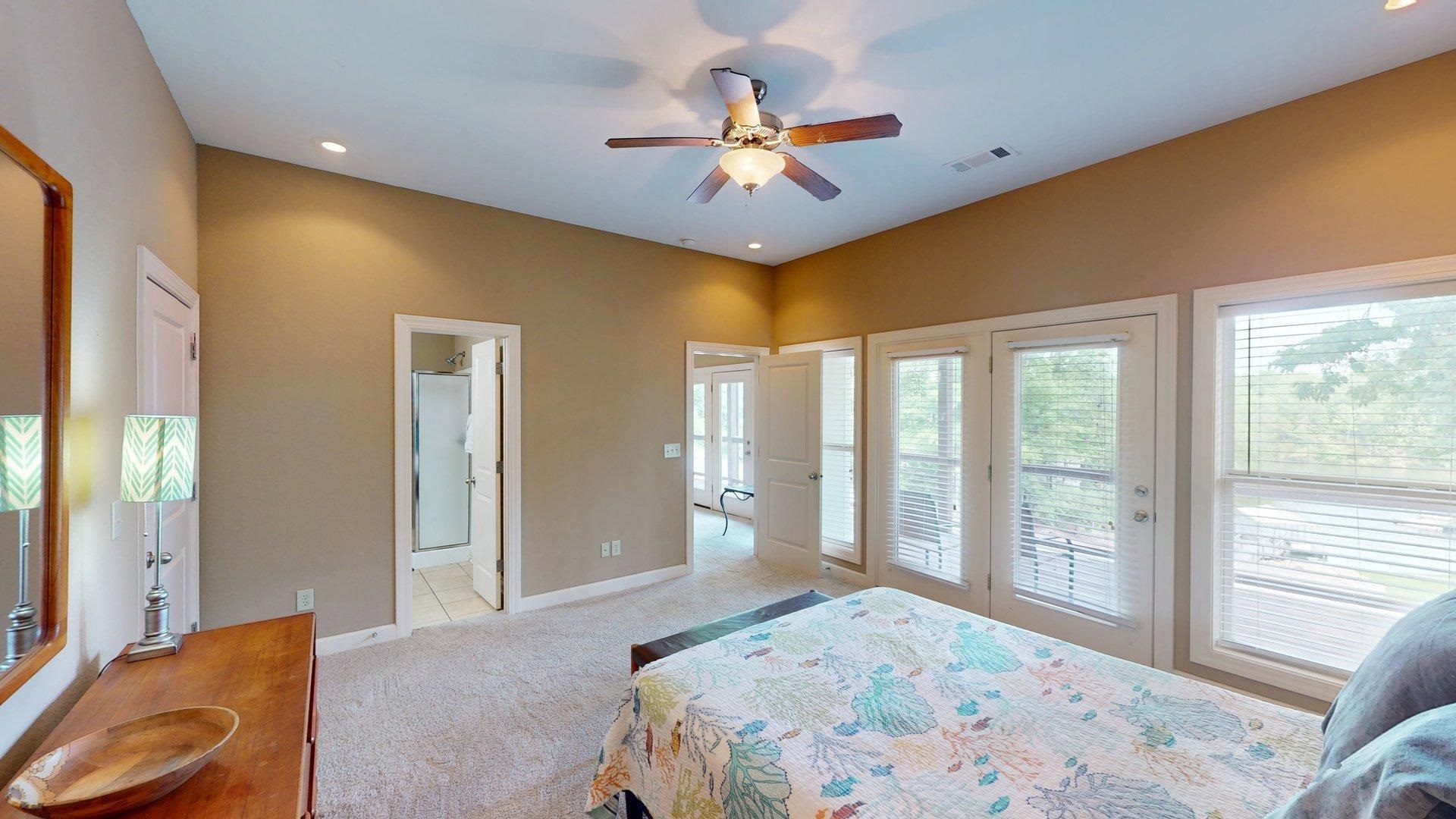 1085 Caney Hollow Road Counce, TN 38326 - Photo 22 of 39 Bedroom featuring access to exterior, light carpet, baseboards, connected bathroom, and ceiling fan