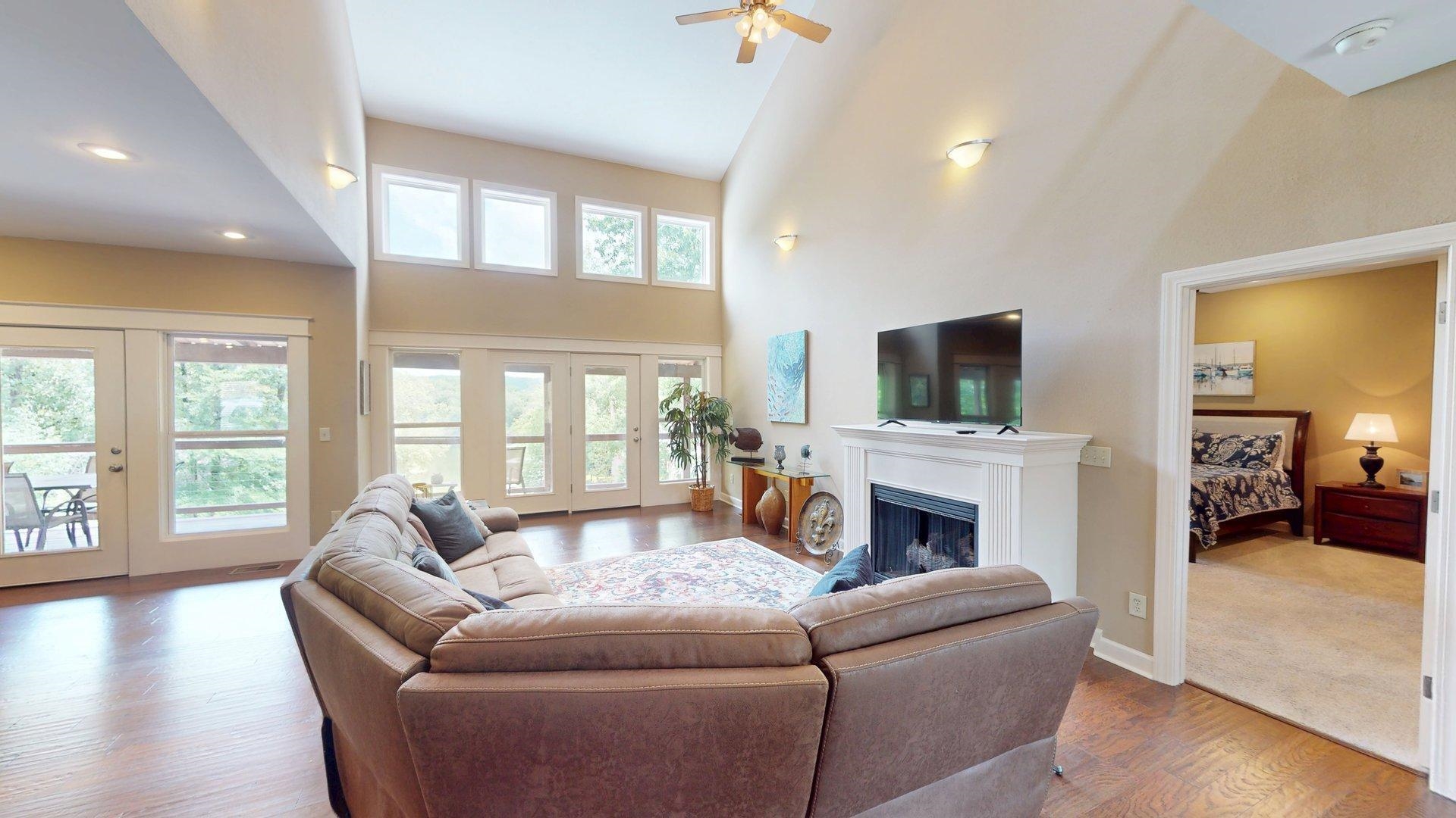 1085 Caney Hollow Road Counce, TN 38326 - Photo 5 of 39 Living area with a fireplace, wood finished floors, a high ceiling, french doors, and ceiling fan