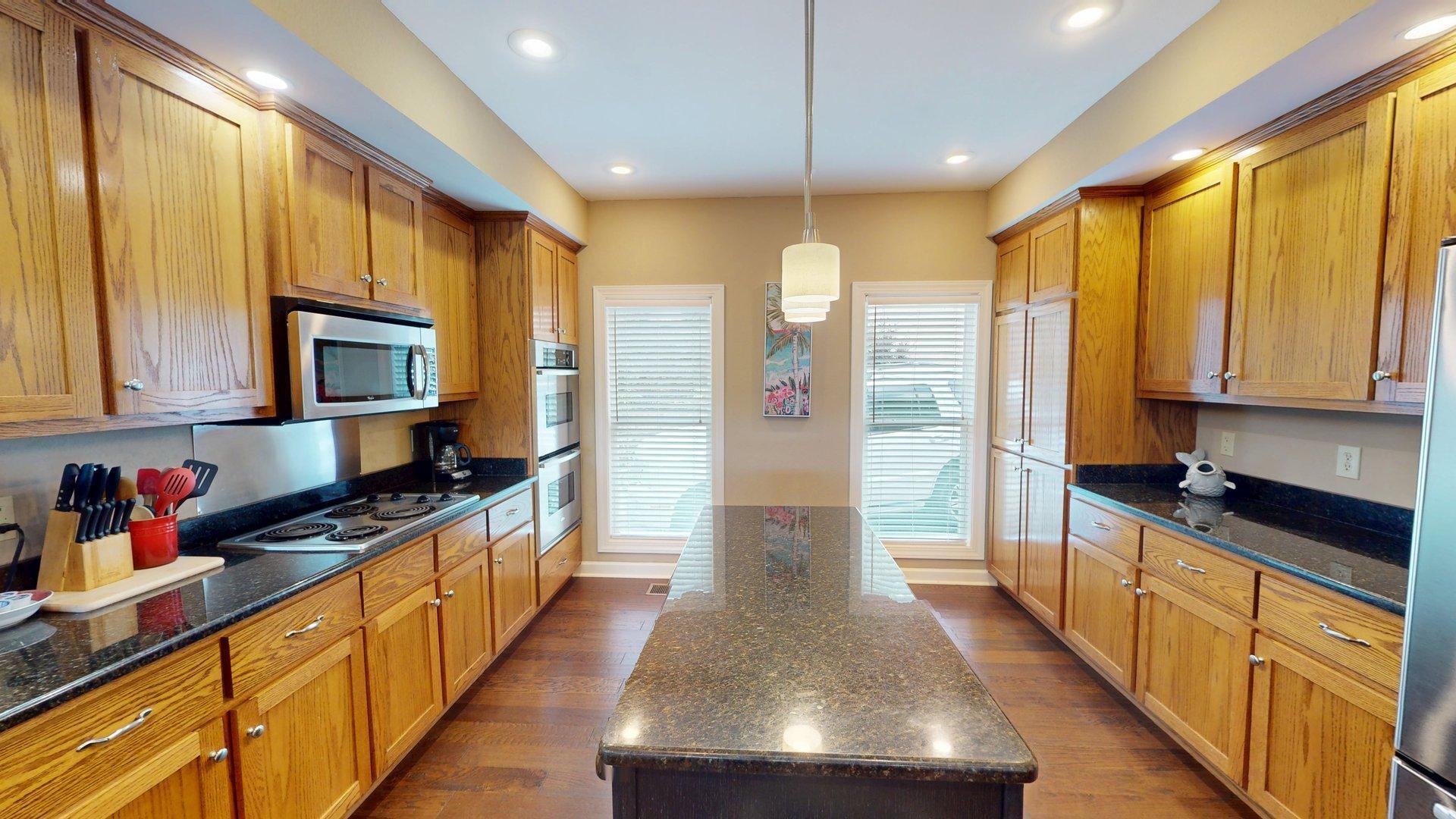1085 Caney Hollow Road Counce, TN 38326 - Photo 9 of 39 Kitchen with stainless steel appliances, a kitchen island, dark wood-style floors, dark stone counters, and recessed lighting