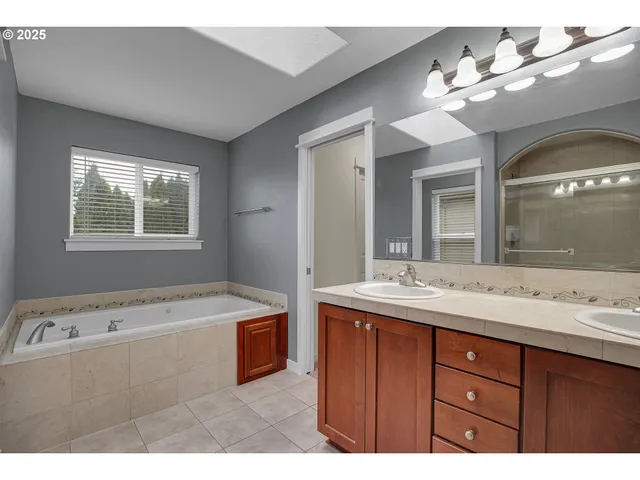 a bathroom with a tub sink and mirror