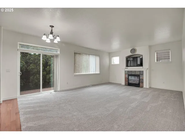 a view of an empty room with a fireplace and a window