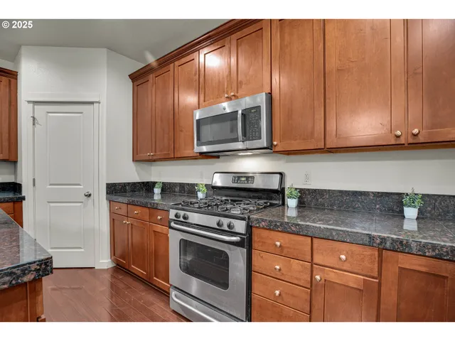 a kitchen with granite countertop wooden cabinets and stainless steel appliances