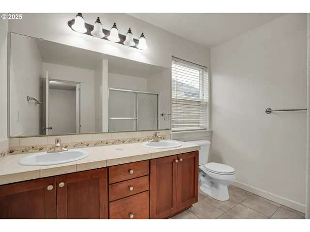 a bathroom with a granite countertop sink a toilet and a mirror