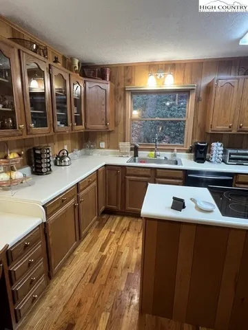 a kitchen with a sink and wooden floor