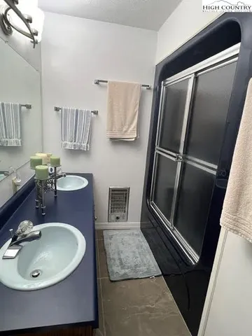 a bathroom with a granite countertop sink and a toilet