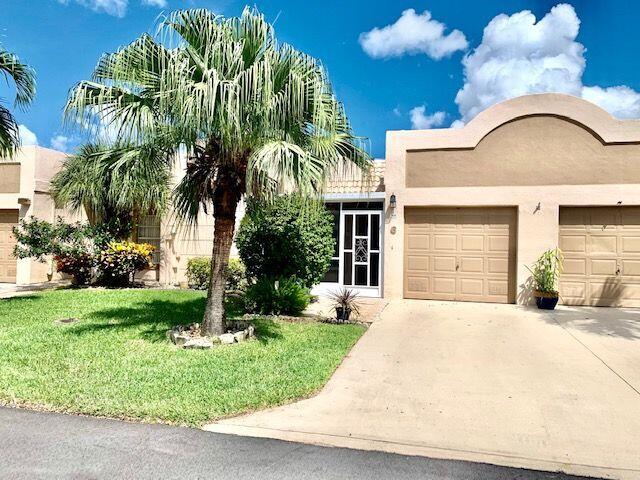 9095 Flynn Circle, Unit 6 Boca Raton, FL 33496 - Photo 1 of 19 a front view of a house with a garden