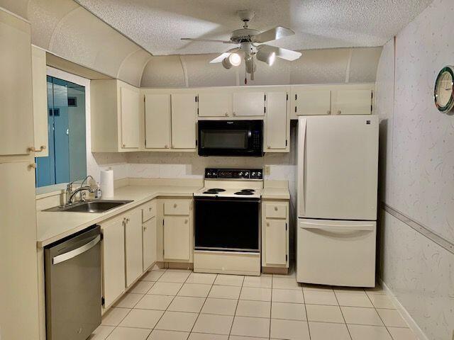 9095 Flynn Circle, Unit 6 Boca Raton, FL 33496 - Photo 3 of 19 a kitchen with a stove a refrigerator and a stove top oven