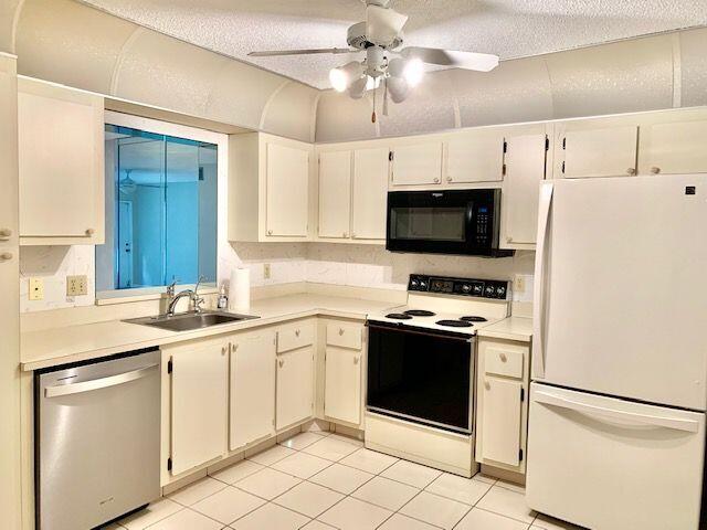 9095 Flynn Circle, Unit 6 Boca Raton, FL 33496 - Photo 4 of 19 a kitchen with stainless steel appliances a stove sink and microwave