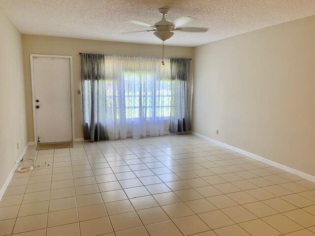 9095 Flynn Circle, Unit 6 Boca Raton, FL 33496 - Photo 7 of 19 an empty room with windows and ceiling fan