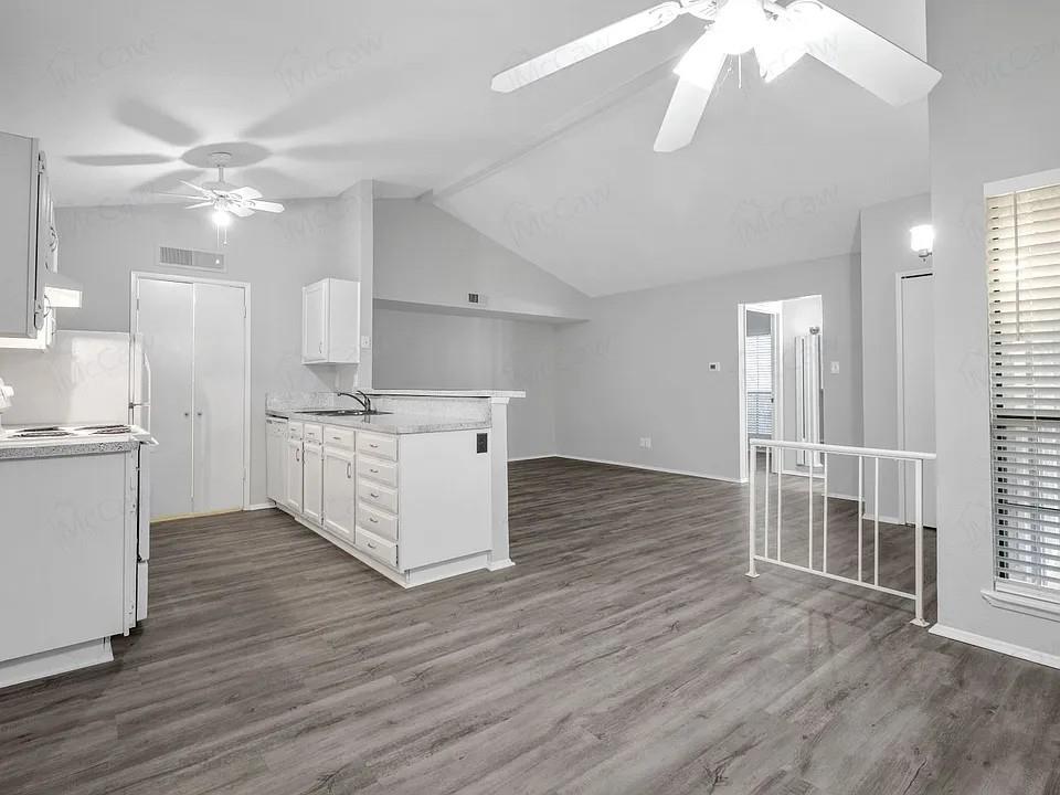 7129 Sorcey Road Dallas, TX 75249 - Photo 5 of 17 Kitchen with a peninsula, white cabinetry, lofted ceiling, light countertops, and white electric range