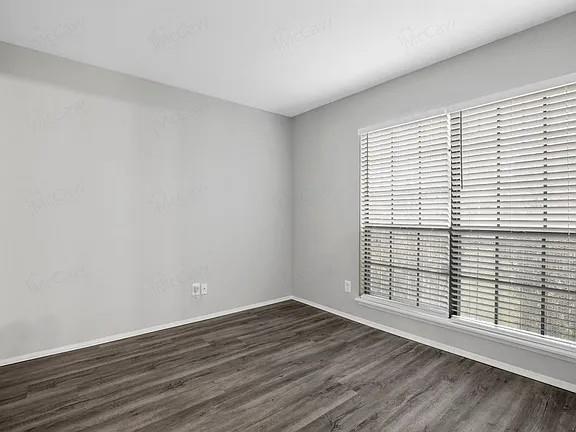 7129 Sorcey Road Dallas, TX 75249 - Photo 10 of 17 Empty room featuring baseboards and dark wood finished floors