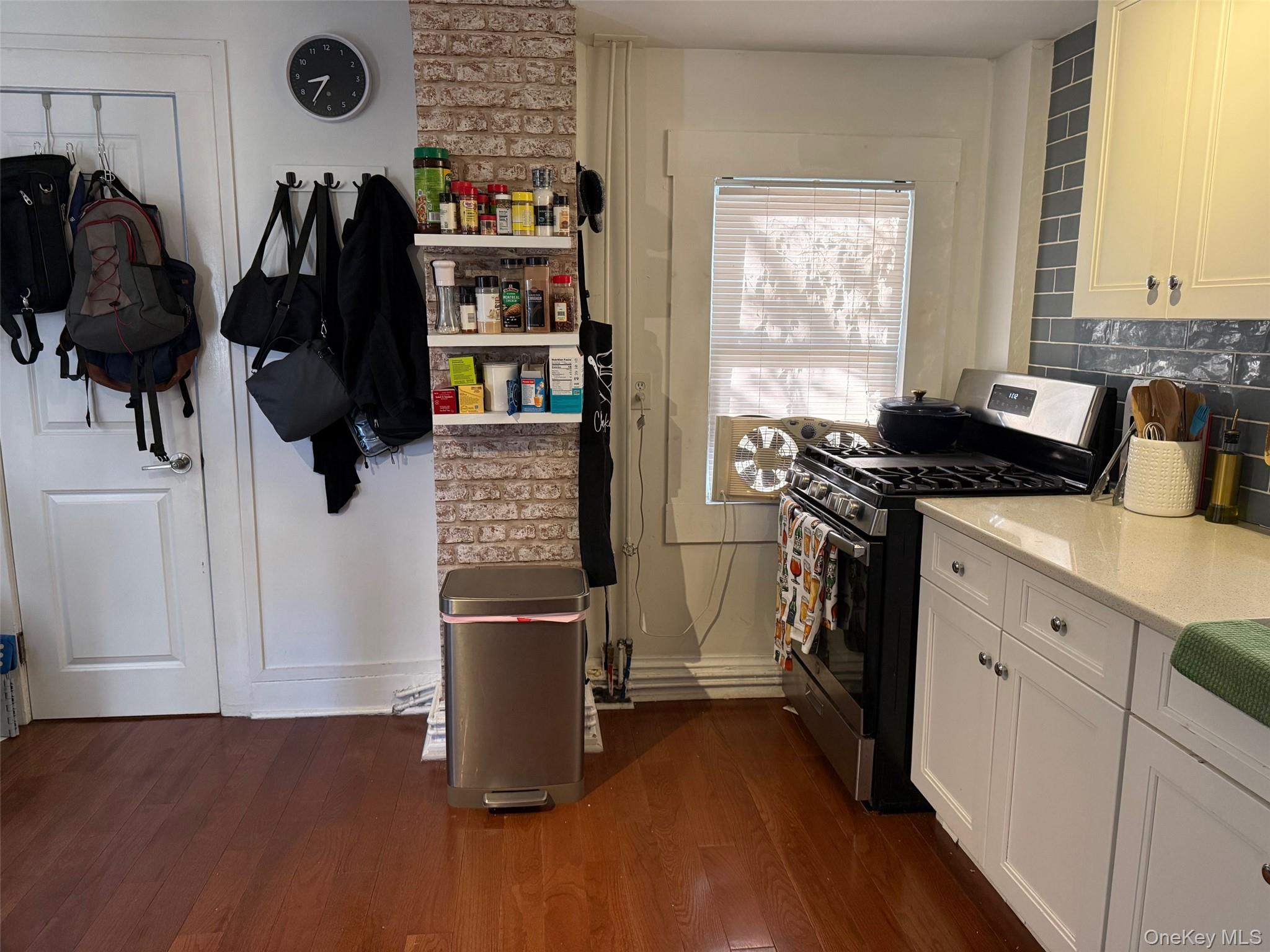 93 Jackson Avenue, Unit 1 Nyack, NY 10960 - Photo 3 of 10 Kitchen featuring stainless steel gas stove, dark wood-type flooring, light stone countertops, and white cabinets