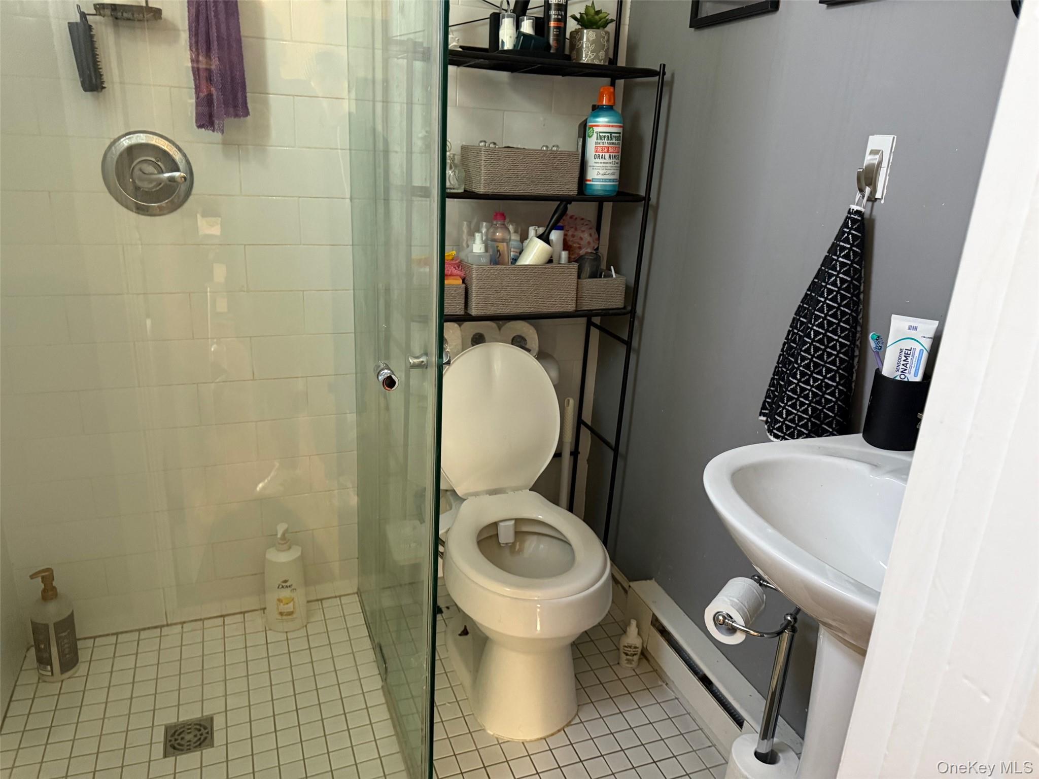 93 Jackson Avenue, Unit 1 Nyack, NY 10960 - Photo 8 of 10 Full bathroom with a shower stall, a baseboard heating unit, and tile patterned flooring