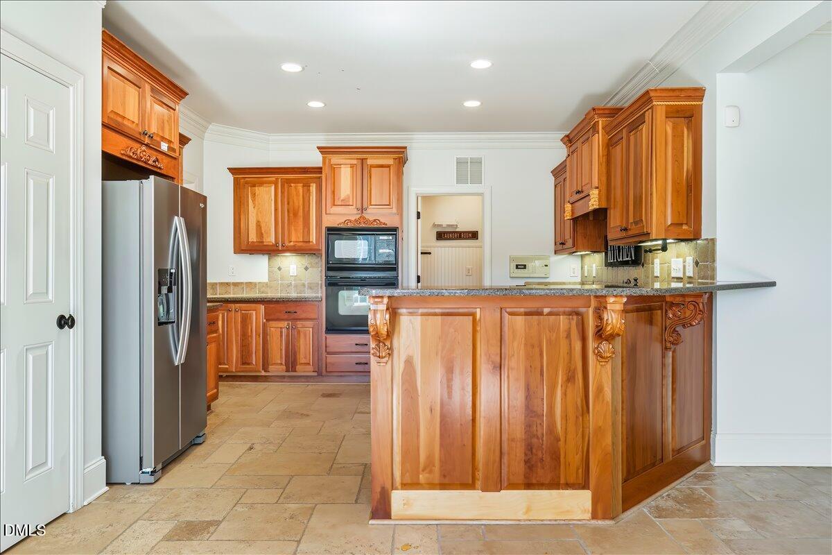 324 Waterville Street Raleigh, NC 27603 - Photo 25 of 82 a kitchen with stainless steel appliances granite countertop a refrigerator and a sink