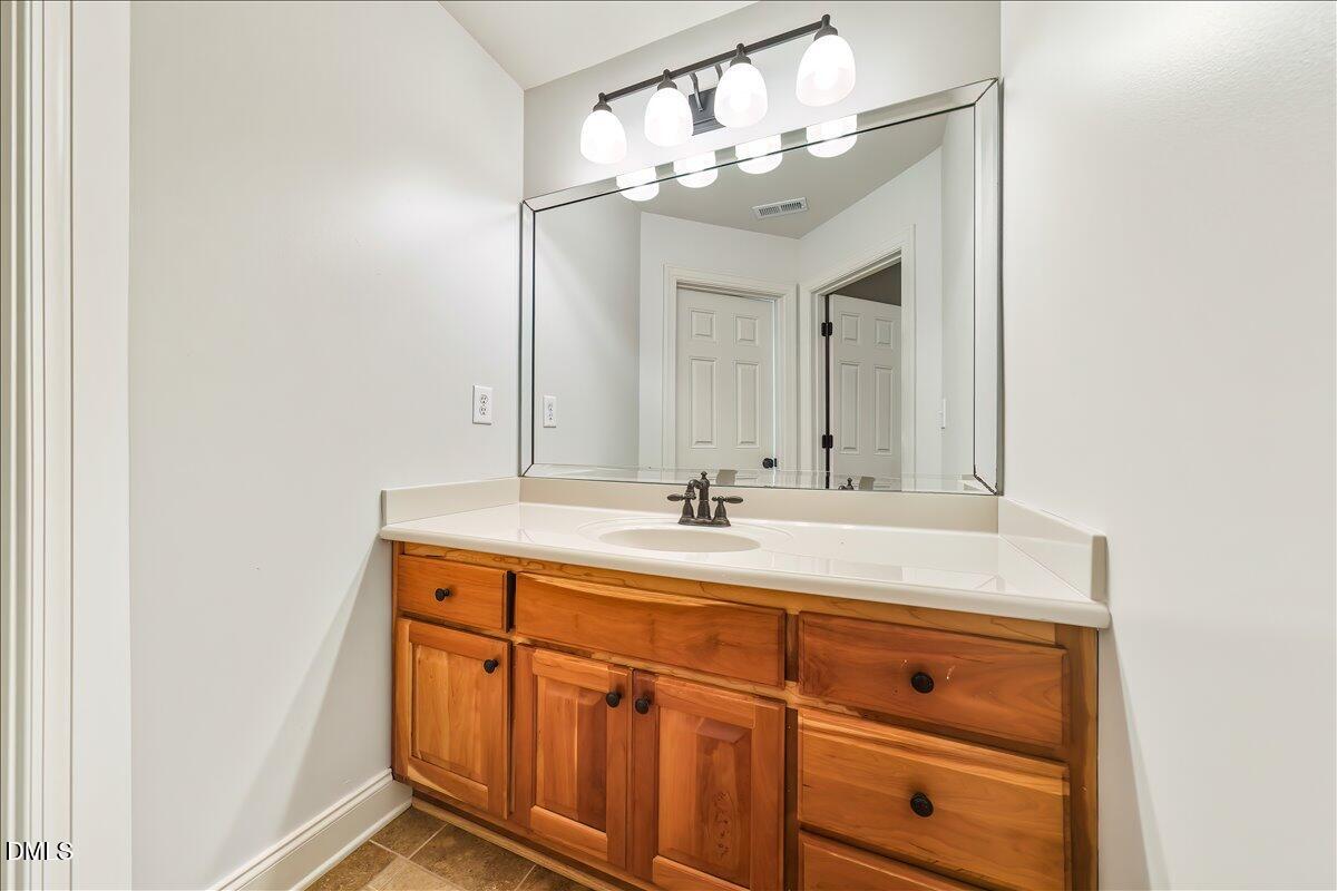 324 Waterville Street Raleigh, NC 27603 - Photo 49 of 82 a bathroom with a sink a vanity and a mirror