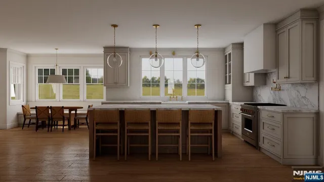 a kitchen with stainless steel appliances granite countertop a stove a refrigerator a kitchen island a dining table and chairs with wooden floor