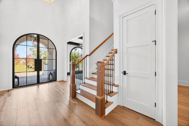 a kitchen with stainless steel appliances granite countertop a stove a sink a dining table and chairs with wooden floor