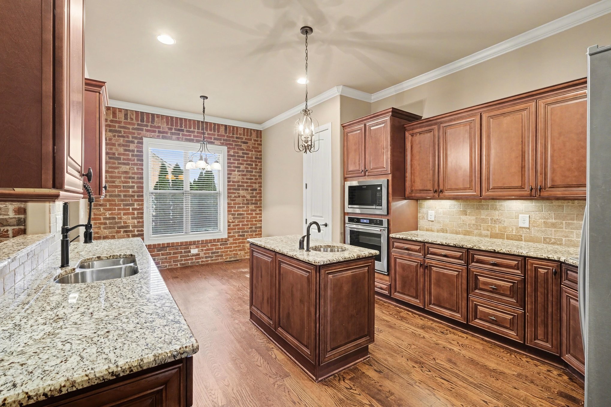 1017 Alice Springs Circle Spring Hill, TN 37174 - Photo 11 of 35 a kitchen with stainless steel appliances granite countertop wooden cabinets a stove top oven a sink and dishwasher