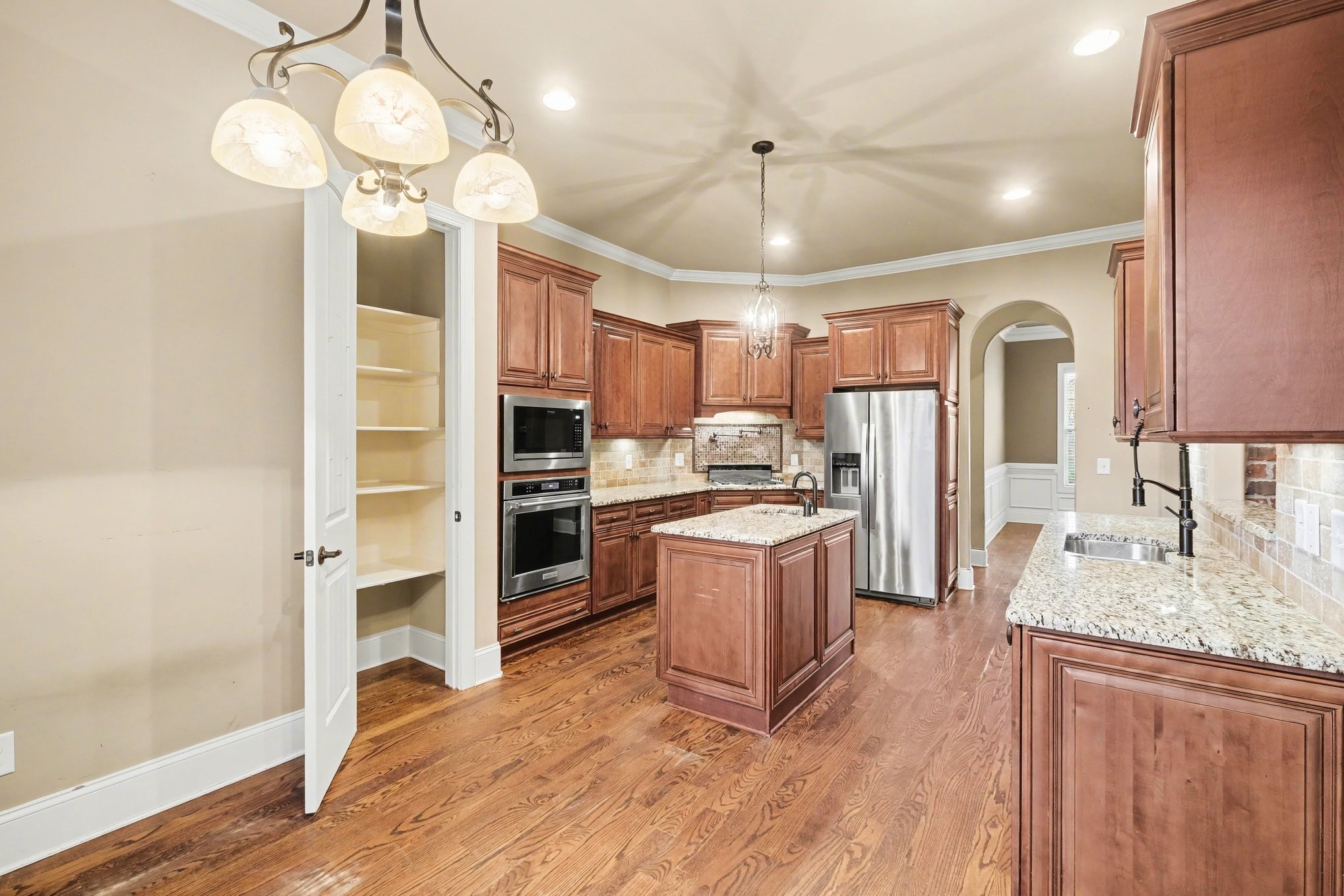 1017 Alice Springs Circle Spring Hill, TN 37174 - Photo 12 of 35 a large kitchen with a center island wooden floor stainless steel appliances and cabinets