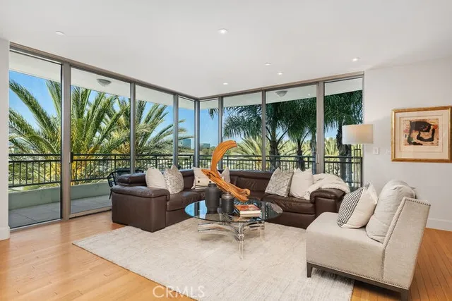 a living room with furniture lamp and a large window with potted plants