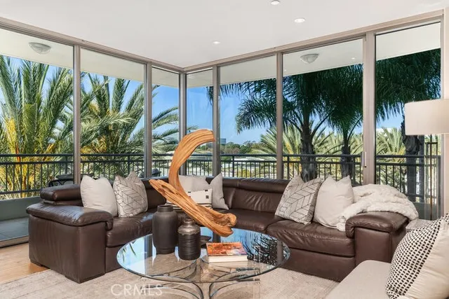 a living room with furniture a fireplace and a floor to ceiling window