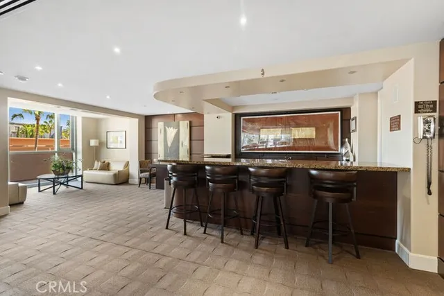 a living room with furniture and a flat screen tv with kitchen view