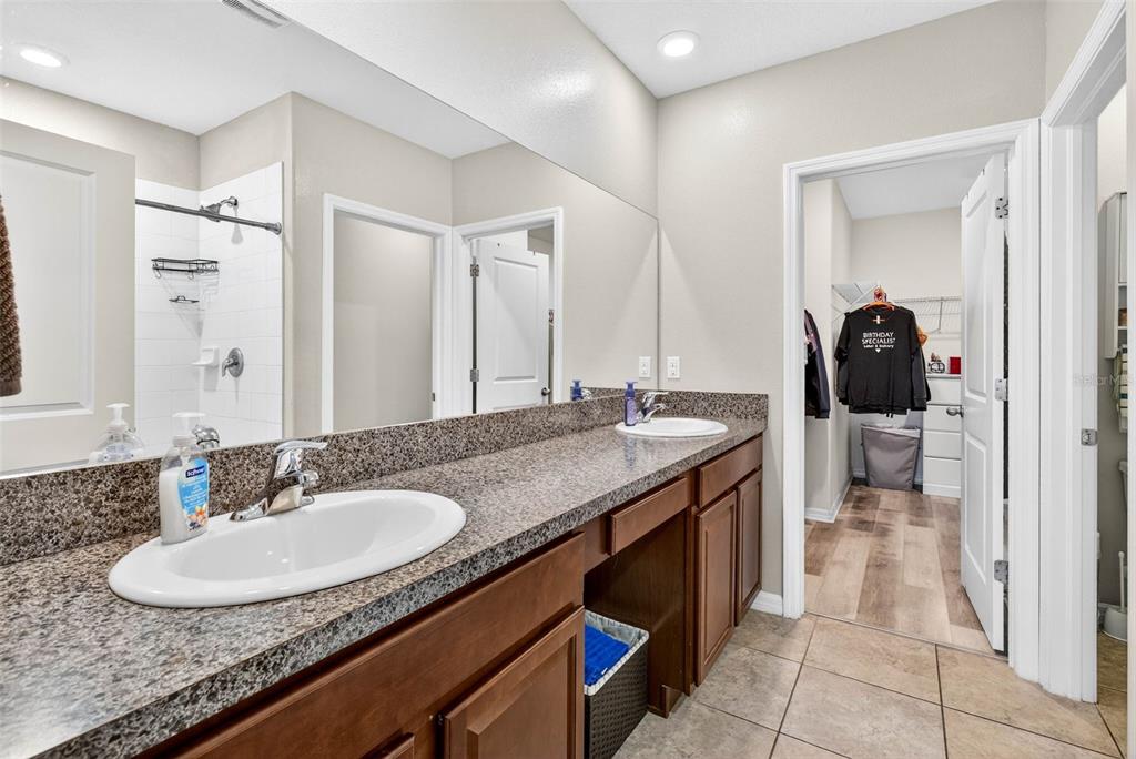 9616 Lemon Drop Loop Sun City Center, FL 33573 - Photo 24 of 53 a en suite bathroom with a granite countertop sink and a mirror