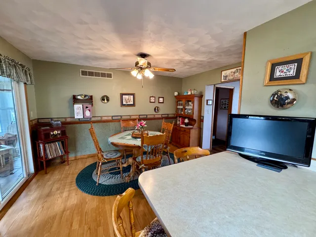 a kitchen with stainless steel appliances wooden cabinets a sink a stove a refrigerator with grey cabinets and wooden floor