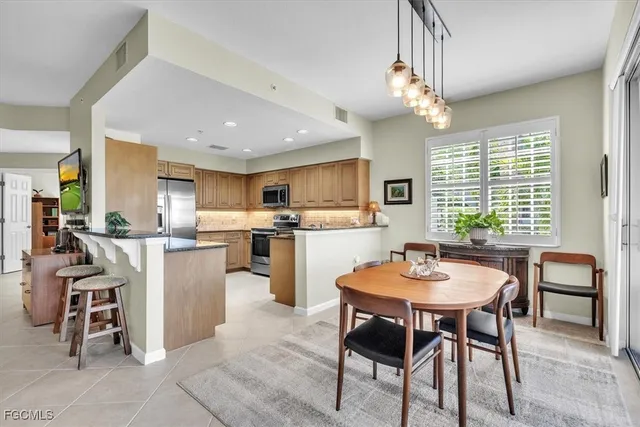 a kitchen with a table chairs refrigerator stove dining table and chairs