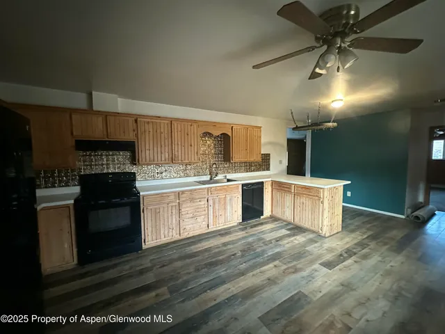 a kitchen with cabinets and wooden floor