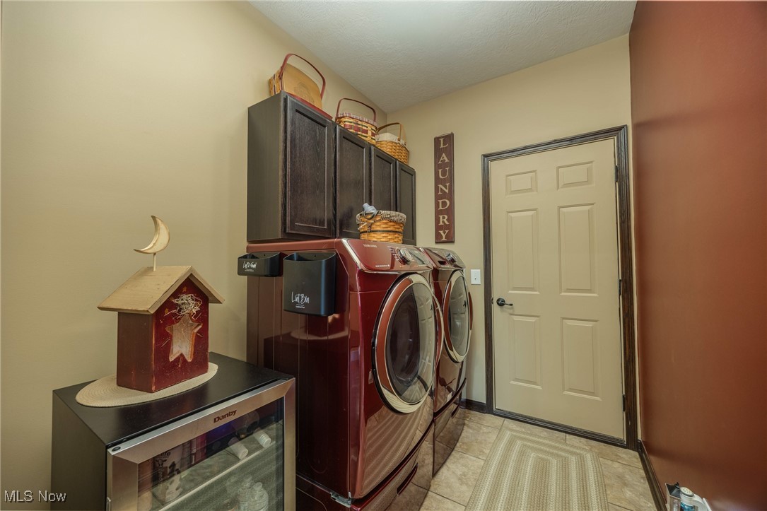 2851 Barnett Ridge Road Fleming, OH 45729 - Photo 33 of 40 Washroom featuring cabinet space, separate washer and dryer and light tile patterned floors