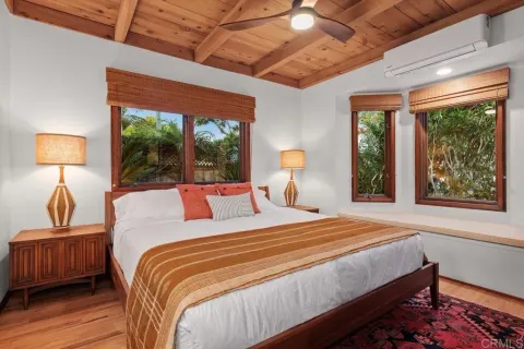 a bedroom with a bed a dresser next to a window