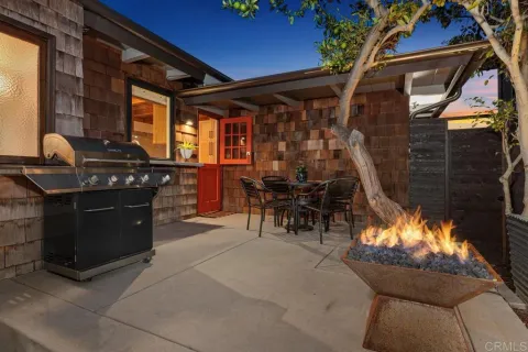 a view of a brick house with a dining table and chairs