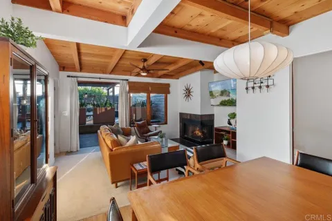 a living room with furniture a flat screen tv and a floor to ceiling window