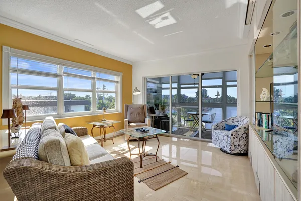 a living room with furniture and floor to ceiling windows