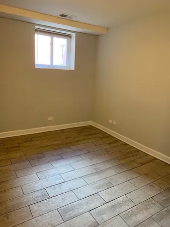 a view of a room with wooden floor and a window