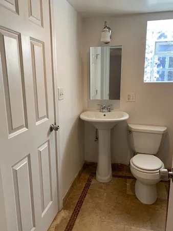 a bathroom with a toilet sink and mirror