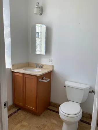 a bathroom with a toilet sink and mirror