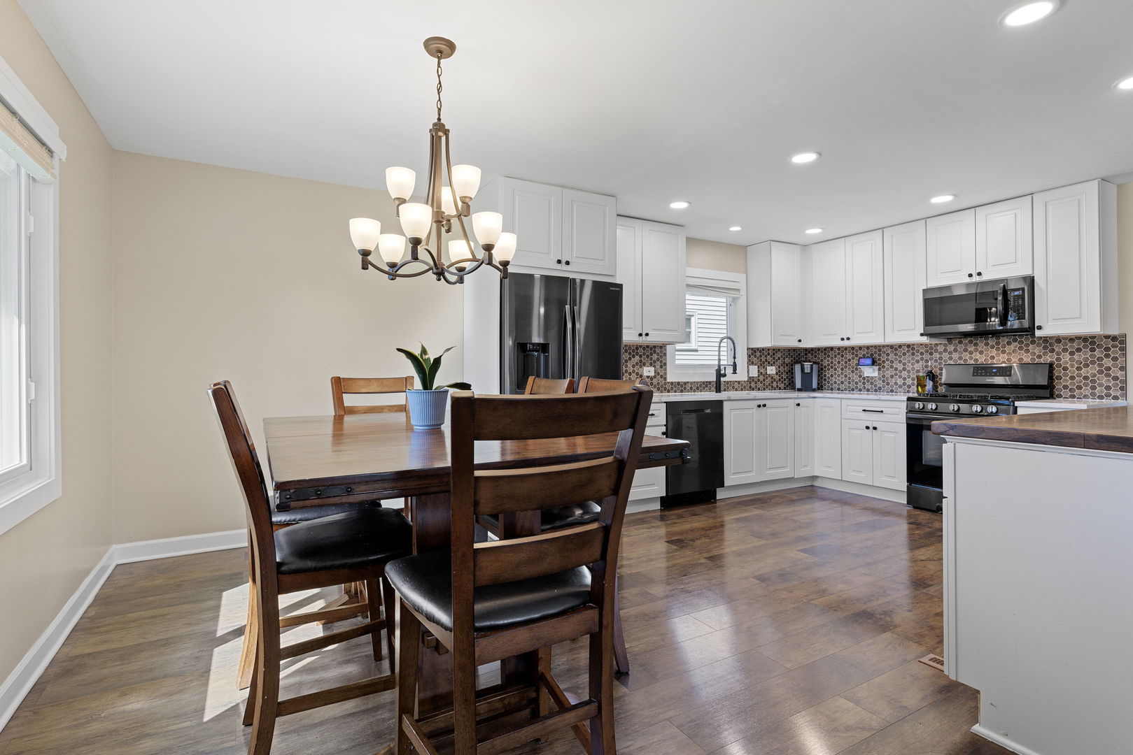 N151 Stanley Street Winfield, IL 60190 - Photo 12 of 27 a kitchen with kitchen island granite countertop stainless steel appliances a stove a sink a microwave a dining table and chairs