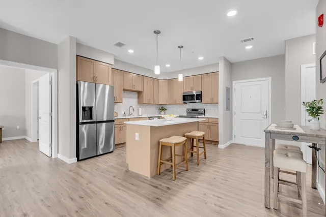 a kitchen with a refrigerator a sink and a stove top oven