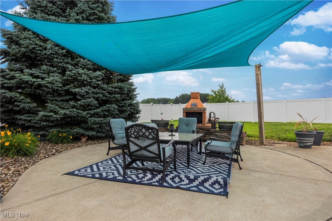 47147 Merriam Road Wellington, OH 44090 - Photo 43 of 49 Vinyl, no maintenance, fenced backyard with exterior fireplace and a patio area